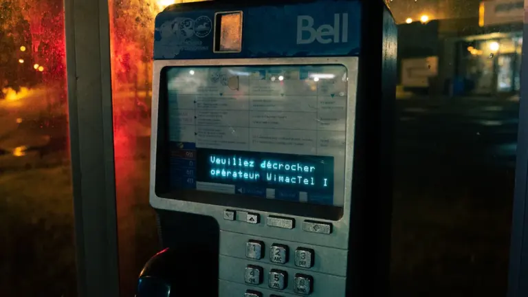 Telefon komórkowy leżący przy oknie w nocy, symbolizujący alerty i komunikację.