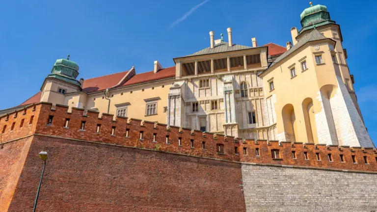 Historyczne mury Zamku Królewskiego na Wawelu w Krakowie pod bezchmurnym niebem