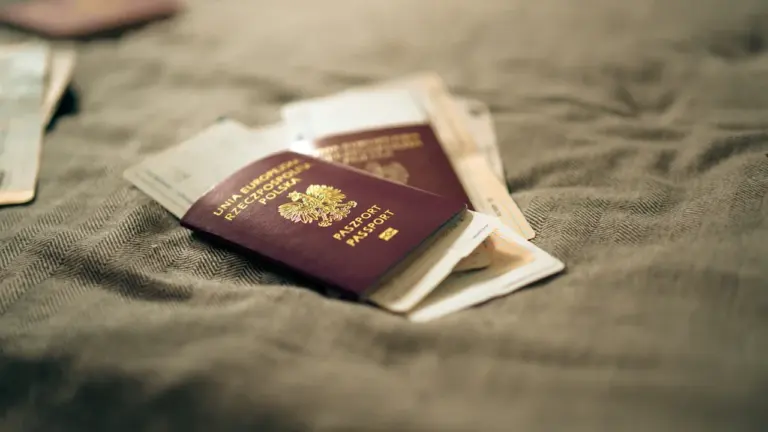 Polski paszport przygotowany do podróży wraz z kartami pokładowymi na stole.