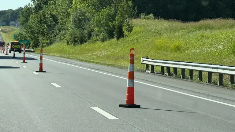 Pomarańczowe pachołki drogowe na pasie ruchu autostrady S7 przy węźle w Tarczynie.