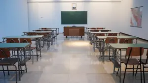 Pusta sala lekcyjna z ławkami i tablicą, miejsce dla białostockich uczniów.