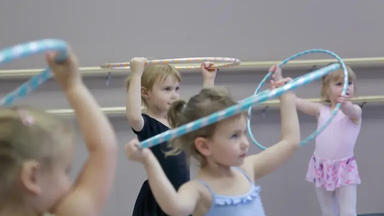 Małe dziewczynki ćwiczą z hula-hop w profesjonalnym studiu tanecznym w Bytomiu