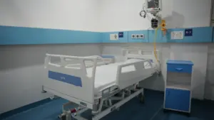 Nowoczesna sala szpitalna z łóżkiem medycznym oraz specjalistycznym sprzętem do monitorowania pacjenta