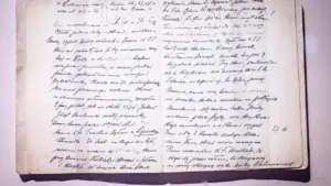 Otwarty stary notatnik z odręcznym pismem na pożółkłych stronach papieru